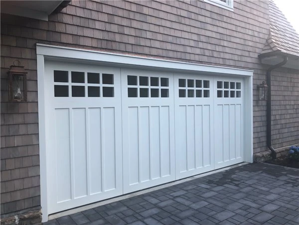 White PVC plastic trim boards installed around residential garage door opening with brick exterior facade mitered corner joints bridging gap between aluminum door track and masonry wall showing clean factory white surface finish White PVC plastic trim boards installed around residential garage door opening with brick exterior facade mitered corner joints bridging gap between aluminum door track and masonry wall showing clean factory white surface finish